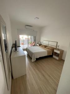 1 dormitorio con 1 cama y vestidor con TV en Ampio Balcone en Buenos Aires