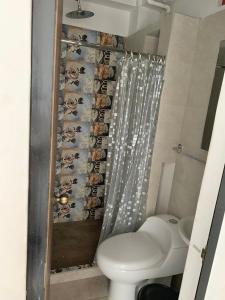 a bathroom with a toilet and a shower curtain at La Curva Apartamentos in Cali +29 photos