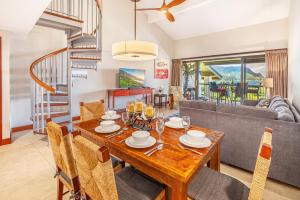 comedor y sala de estar con mesa de madera y sillas en Hanalei Bay Resort 7307, en Princeville