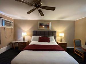 1 dormitorio con 1 cama grande y ventilador de techo en Skyline Inn, en Atlantic City