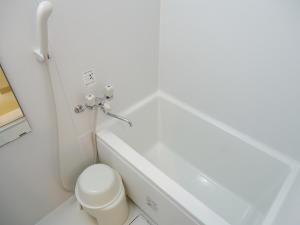 a white bathroom with a toilet and a sink at Shin-Okubo City Hotel in Tokyo +18 photos
