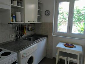 a kitchen with a sink and a washing machine at Casa Liliana By the Sea in Mali Lošinj