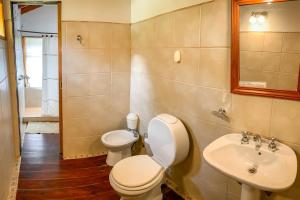a bathroom with a toilet and a sink at Cabañas Posada de las Flores in Tolhuin