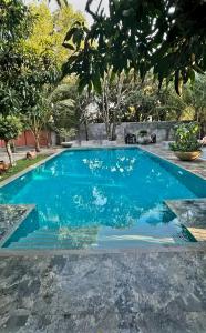 a swimming pool with blue water in a yard at My Village in Tissamaharama
