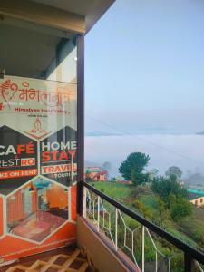 a balcony of a house with a view of a field at MangalMurti Himalyan Hotel in Almora