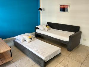 2 camas en una habitación con una pared azul en Departamento con terraza, parrilla y piscina en Buenos Aires