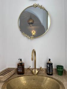 a bathroom sink with a mirror and a sink at Riad Black Doors in Marrakesh