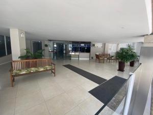 an empty lobby with a bench and tables in a building at Apê coração BC 1 qto 4 pess 300m Praia Garagem Priv in Balneário Camboriú