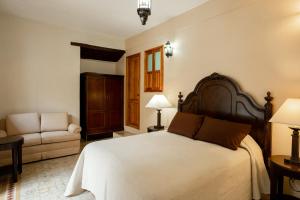 1 dormitorio con 1 cama, 1 sofá y 1 silla en La Casa Veintidós, en Guanajuato