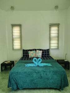 a bedroom with a large bed with a blue blanket at Bais City Home Staycation in Bais