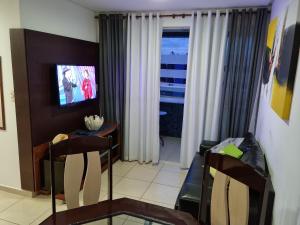 uma sala de estar com uma televisão e uma mesa e cadeiras em Le Parc Residencial - Manaira - Joao Pessoa em João Pessoa