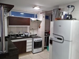 uma cozinha com um frigorífico branco e um fogão em Le Parc Residencial - Manaira - Joao Pessoa em João Pessoa