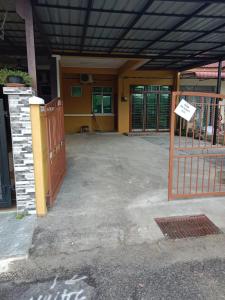 a building with a gate and a sign in front of it at Ajila Inn in Sepang