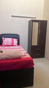 um quarto com uma cama com um espelho e uma cómoda em Ajila Inn em Sepang