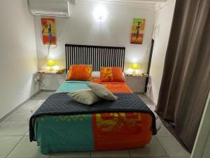 1 dormitorio con 1 cama con 2 almohadas en Kaza Mango en Sainte-Luce