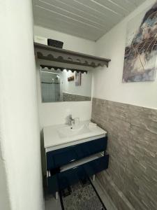 a bathroom with a sink and a mirror at Kaza Mango in Sainte-Luce