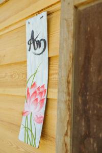 ein Schild an einer Wand mit einer Blume und einer Biene in der Unterkunft Midori Coffee Farm in Da Lat