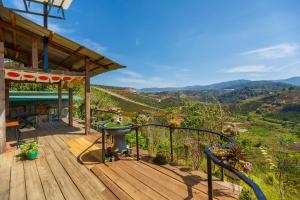 a wooden deck with a view of the mountains at Midori Heritage Coffee Farm in Da Lat