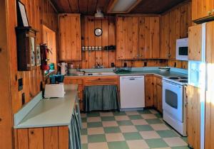 eine Küche mit Holzschränken und weißen Geräten in der Unterkunft Cabin #5 in Strawberry