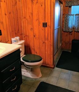 a bathroom with a toilet with a green lid at Cabin #5 in Strawberry