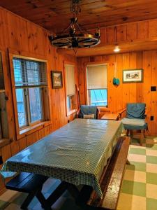 ein Esszimmer mit einem Tisch in einem Holzzimmer in der Unterkunft Cabin #5 in Strawberry