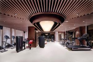 een fitnessruimte met loopbanden en fitnessapparatuur aan het plafond bij Metropolitan Residence in Shanghai