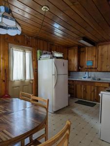 eine Küche mit einem Tisch und einem weißen Kühlschrank in der Unterkunft Cabin #2 in Strawberry