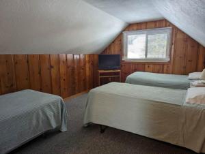 ein Schlafzimmer mit 2 Betten und einem TV in der Unterkunft Cabin #2 in Strawberry