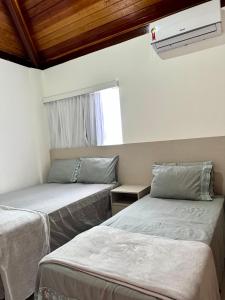 two beds in a room with a window at Casa Praia dos Carneiros in Tamandaré +28 photos