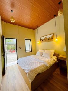 una camera con un grande letto e un soffitto in legno di Boong Home - Pác Bó, Cao Bằng 