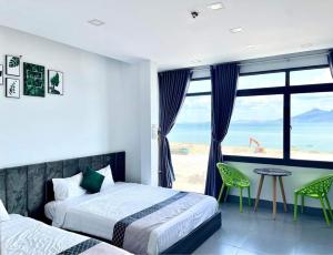 a bedroom with two beds and a view of the ocean at Homestay Thien Trang Sea View in Quy Nhon