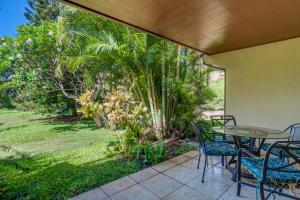 a patio with a table and chairs and trees at Koa Resort 1b in Kihei