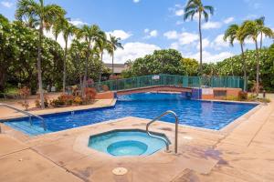 a large swimming pool with palm trees in a resort at Koa Resort 1b in Kihei