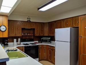 a kitchen with wooden cabinets and a white refrigerator at Cabin #10 in Strawberry