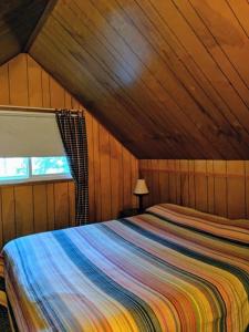 a bedroom with a bed in a wooden room at Cabin #10 in Strawberry