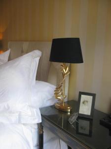 una lámpara en una mesa de cristal junto a una cama en Flemings Country House en Cork