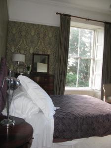 a bedroom with a large bed and a window at Flemings Country House in Cork