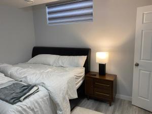 a bedroom with two beds and a lamp on a night stand at A very nice Basement ensuite. in Calgary