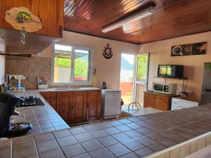 cocina con armarios de madera y encimera en CASAMELIAS "La glycine", en Cilaos