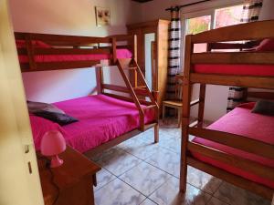 a room with two bunk beds and a table at CASAMELIAS "La glycine" in Cilaos