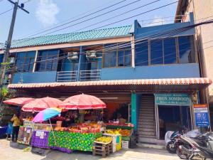 un chiosco della frutta con ombrelloni di fronte a un edificio di Phonsomboon Guesthouse a Ko Tao