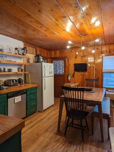 a kitchen with a table and a white refrigerator at Cabin #8 in Strawberry