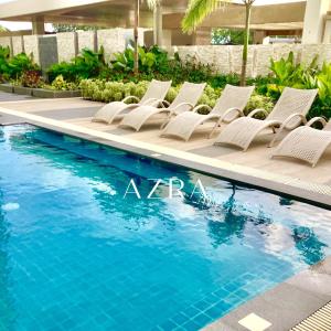 a row of chairs next to a swimming pool at AZRA Bacolod at Mesavirre Garden Residences in Bacolod