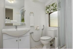 a white bathroom with a toilet and a sink at Valley Heights Guest House and B & B in Cape Town