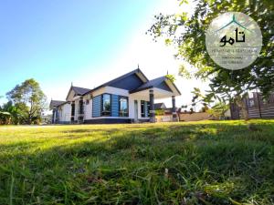 a house with a lawn in front of it at Tamu Homestay Terengganu in Kuala Terengganu