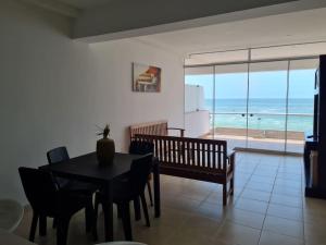 un comedor con mesa y sillas y el océano en Apartamento familiar de lujo 104, en San Bartolo
