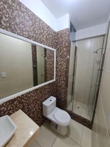 La salle de bains est pourvue de toilettes, d'un lavabo et d'une douche. dans l'établissement Apartamento familiar de lujo 104, à San Bartolo