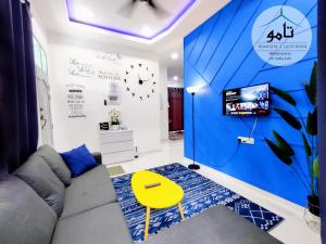 sala de estar con sofá y TV en Tamu Homestay Terengganu en Kuala Terengganu
