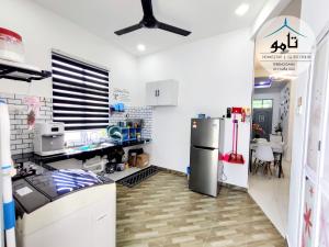 a kitchen with a refrigerator and a table at Tamu Homestay Terengganu in Kuala Terengganu