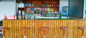 a wooden bar with stools in front of a counter at RNA Guesthouse in Moalboal